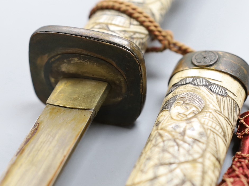 A late 19th century Japanese wakizashi sword, the blade 47.5cm, with sectional stag's horn scabbard and hilt carved with warriors and other figures, gilt metal mounted